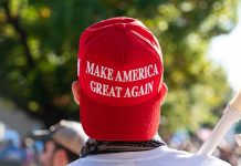 Red "Make America Great Again" hat on person's head.