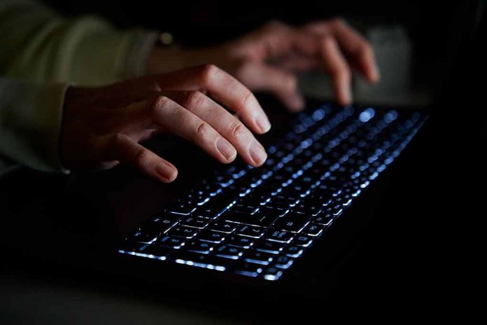 Hands typing on a backlit keyboard in darkness