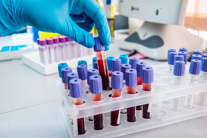 Gloved hand handling blood samples in a laboratory.